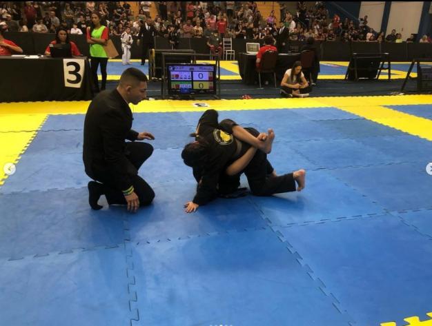 árbitro observa uma luta de jiu jitsu